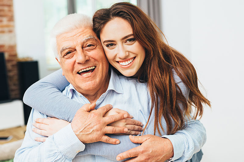 family-caregiver-hugging-senior-with-parkinsons