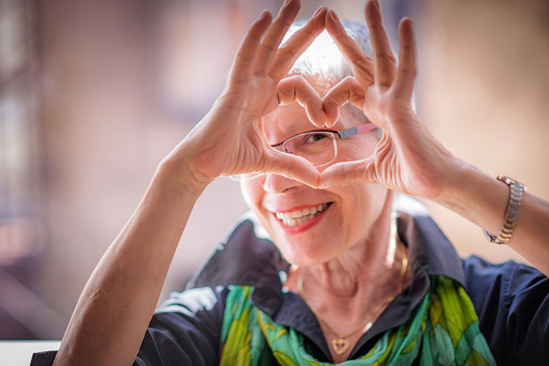 happy-lady-looking-through-heart-made-with-hands